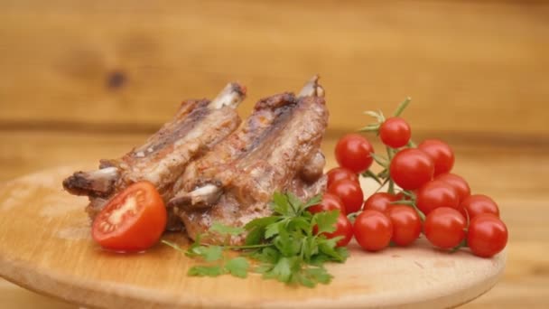 Fried meat and tomatoes spin on a wooden tray — Stock Video