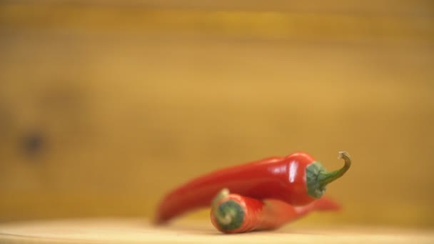 Πιπεριές τσίλι που περιστρέφονται σε ένα ξύλινο τραπέζι — Αρχείο Βίντεο