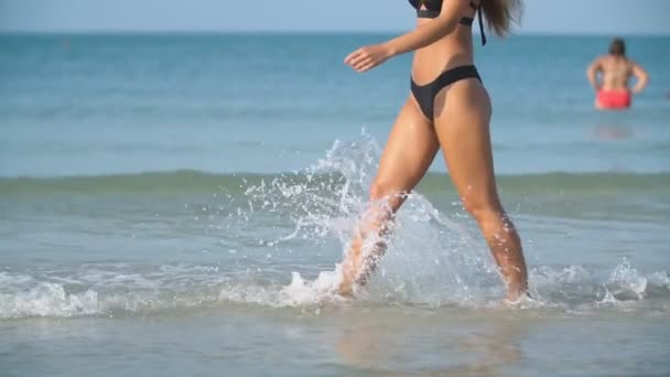 Ένα κορίτσι σε ένα μαγιό τρέχει σε μια βαθιά θάλασσα — Αρχείο Βίντεο