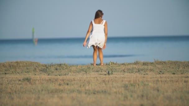 Fille dans une robe blanche près de la mer — Video