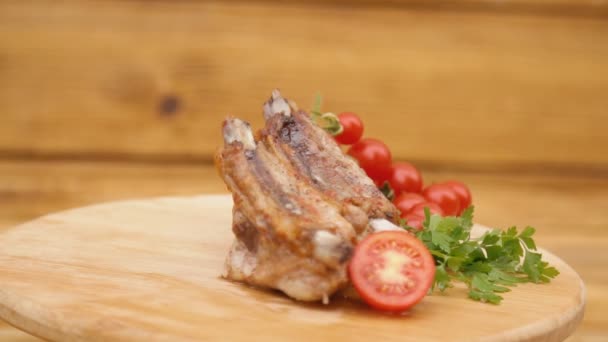 Gebratenes Fleisch und Tomaten drehen sich auf einem Holzblech — Stockvideo