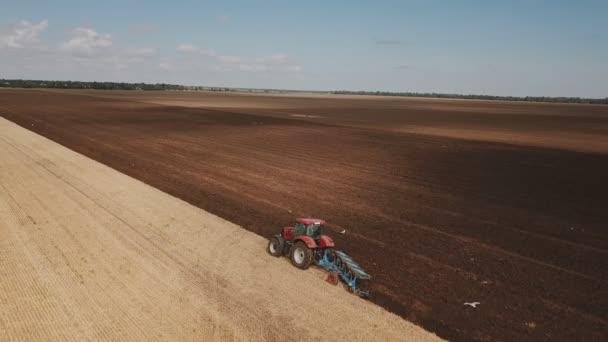 Flygning över en traktor som plogar marken — Stockvideo