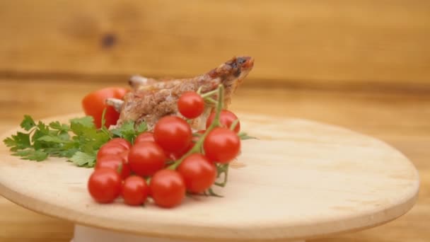 Смажене м'ясо і помідори обертаються на дерев'яному підносі — стокове відео