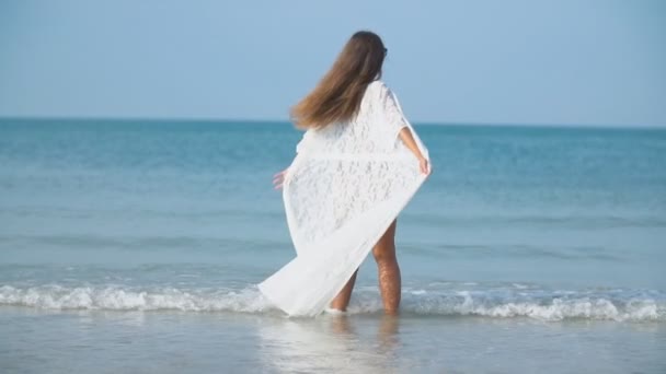 수영복을 입은 소녀가 얕은 바다를 걷고 있다 — 비디오