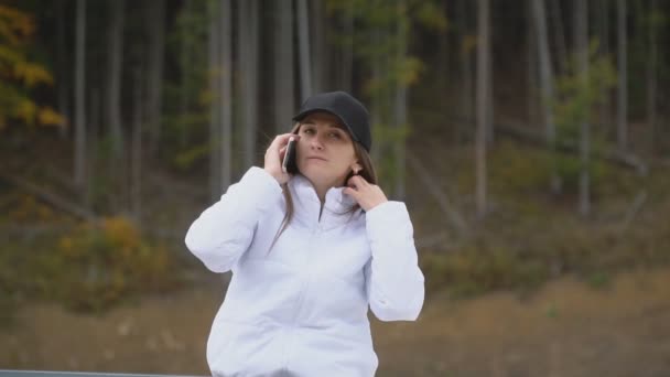 Girl in a cap is talking on the phone — Stock Video