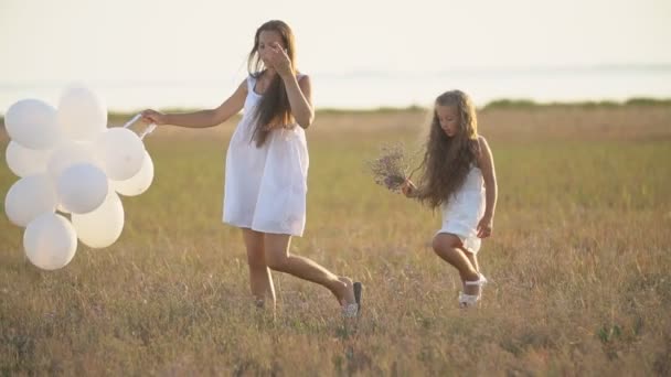 Kızı ve beyaz balonları olan bir anne. — Stok video