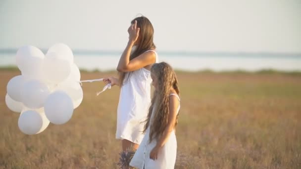 Мама с дочерью и белыми шариками — стоковое видео