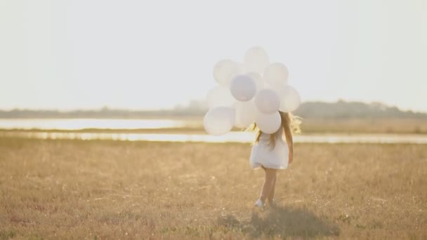 Mädchen im weißen Kleid und mit weißen Luftballons — Stockvideo