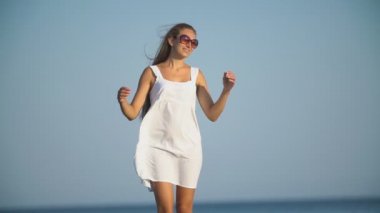 Deniz kenarındaki beyaz elbiseli kadın.