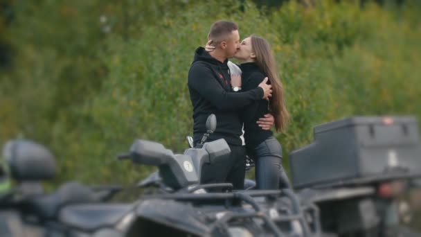 Couple kisses standing on ATVs — Stock Video