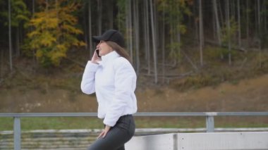 Şapkalı kız telefonda konuşuyor.