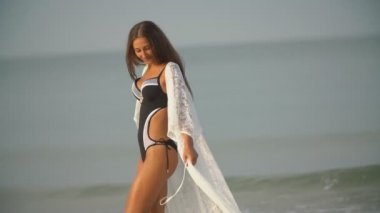 Mayolu kız deniz kenarında yürüyor.