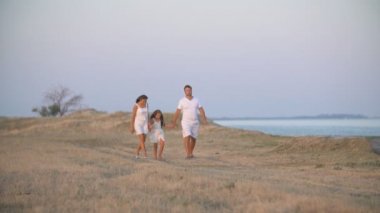 Aile toprak bir yolda yürüyor.
