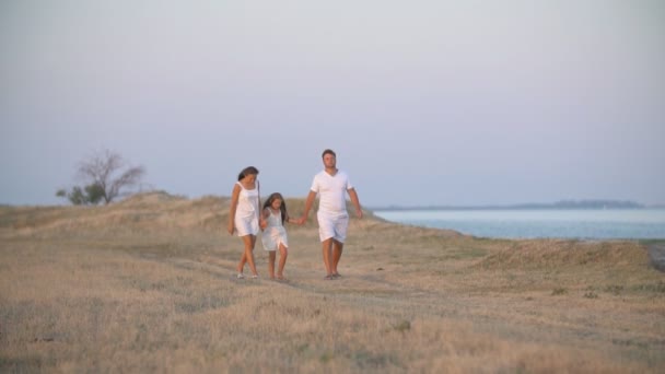 Familia camina en un camino de tierra — Vídeos de Stock