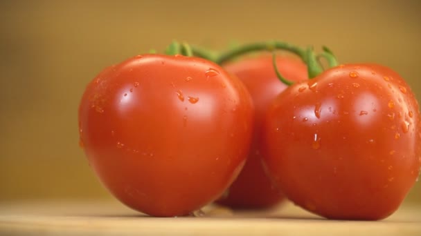 Los tomates giran sobre una mesa de madera — Vídeos de Stock