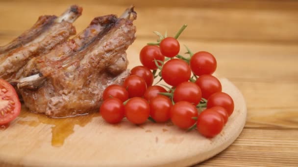 Carne con tomates en una bandeja de madera — Vídeo de stock