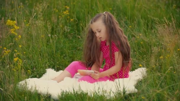 Meisje zitten in de natuur met een telefoon — Stockvideo