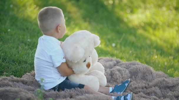 Хлопчик грає з плюшевим ведмедем — стокове відео