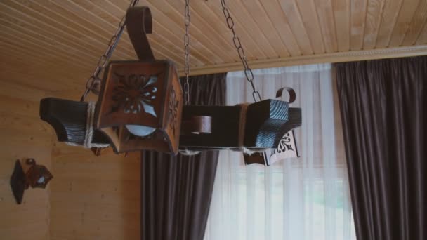 Una lámpara de araña de madera se balancea de ida y vuelta — Vídeos de Stock