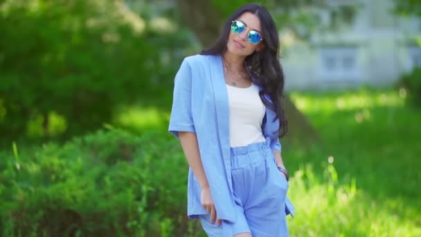 Kobieta w niebieskich kostiumach i okularach przeciwsłonecznych — Wideo stockowe