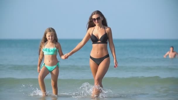 Mamá y su hija van por el mar — Vídeo de stock