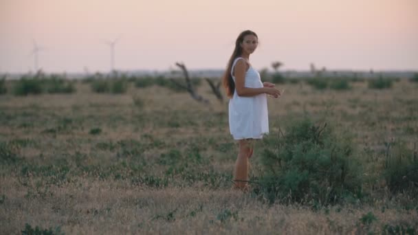 Mujer en un vestido blanco y con el pelo largo — Vídeo de stock