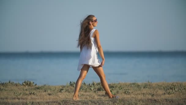 Дівчина в білій сукні біля моря — стокове відео