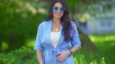 Mavi kostümlü ve güneş gözlüklü kadın.