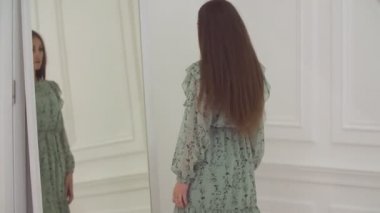 Kız aynada kendine bakıyor.