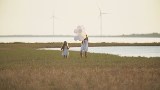 Mamma med dotter och ballonger gå — Stockvideo