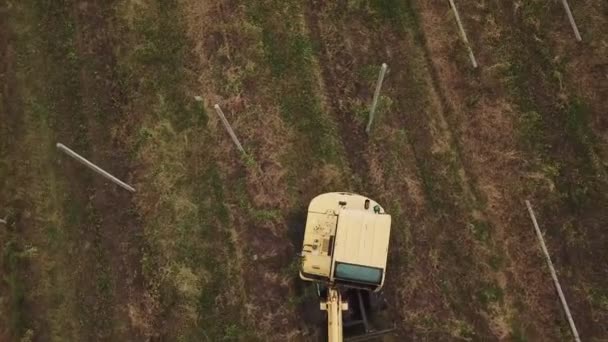 Excavadora conduce postes de hormigón en el suelo — Vídeos de Stock