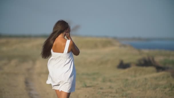 Mädchen in einem weißen Kleid in der Natur — Stockvideo