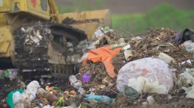 Tırtıl buldozerleri çöpleri bir yığın halinde topluyor.
