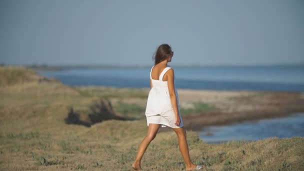 Menina em um vestido branco na natureza — Vídeo de Stock