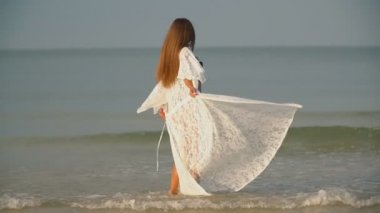 Mayolu kız deniz kenarında yürüyor.