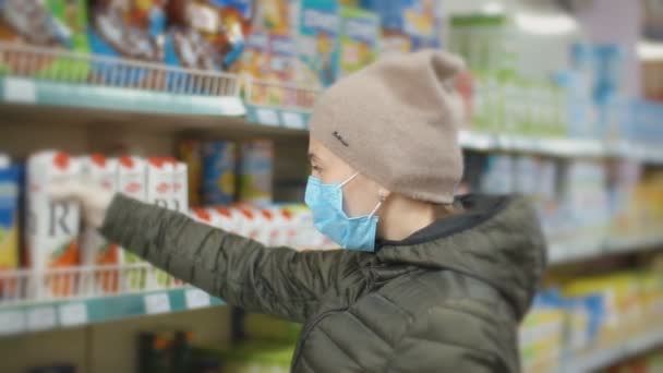 Vrouw in medisch masker koopt producten — Stockvideo