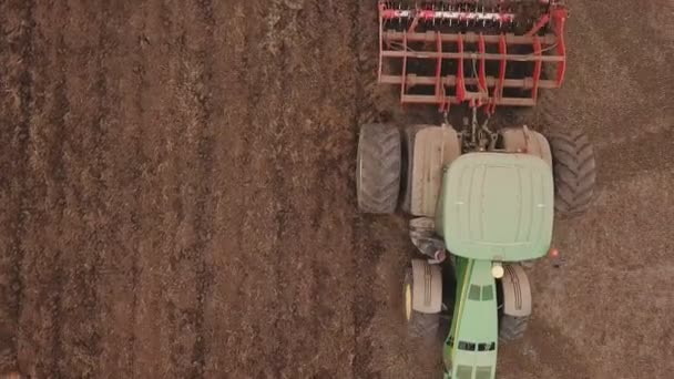Un tractor grande arada un campo — Vídeo de stock