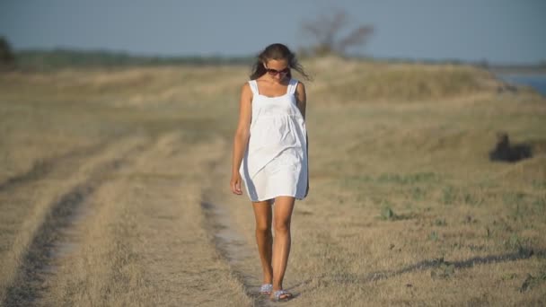 Menina em um vestido branco caminha — Vídeo de Stock