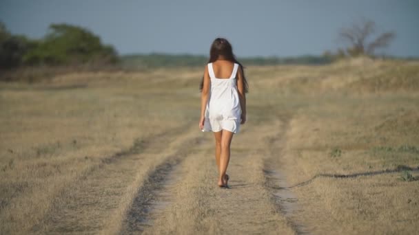 Дівчина в білій сукні гуляє — стокове відео