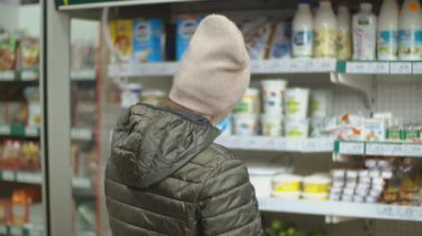 Süpermarkette koruyucu maskeli bir kadın.