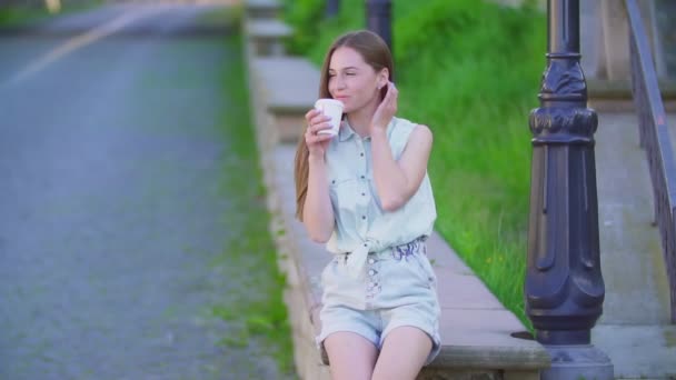 Hermosa chica en pantalones cortos y una taza de plástico — Vídeos de Stock
