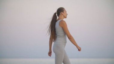 Kız sahilde antrenman yapıyor.