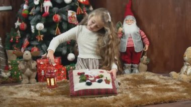 Noel ağacının arka planında yastıklı bir kız