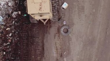 Buldozer çöpleri bir yığın halinde topluyor.