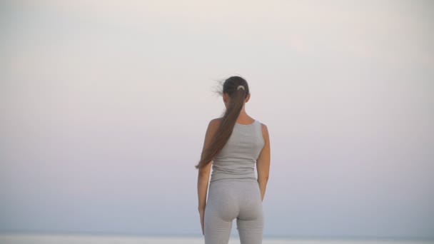 海を背景に運動をしている女の子 — ストック動画