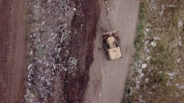 Buldozer çöpleri bir yığın halinde topluyor.