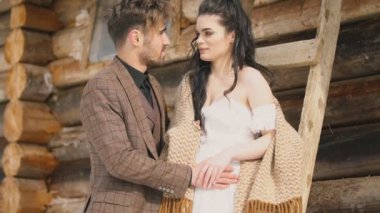 Ahşap bir evin arka planında bir çift.