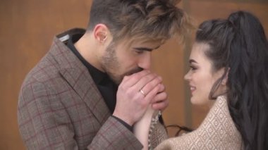 Bir erkek kız arkadaşının ellerini ısıtır.