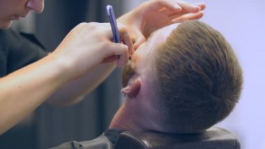 Bir adamın sakalı tıraş edildi.