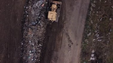 Buldozer çöpleri yığıyor.
